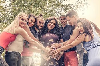 Schwangere umgeben von Freundinnen und Freunden