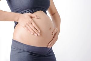 Schwangere tastet ihren Bauch ab