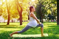 Schwangere macht Yoga im Park