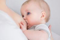 Baby saugt an der Brust seiner Mutter