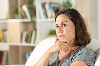 Nachdenkliche Frau mittleren Alters