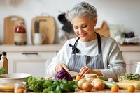 Frau mittleren Alter bereitet veganes Gericht zu